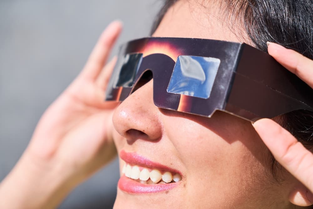 Solar eclipse glasses Women with solar eclipse glasses.