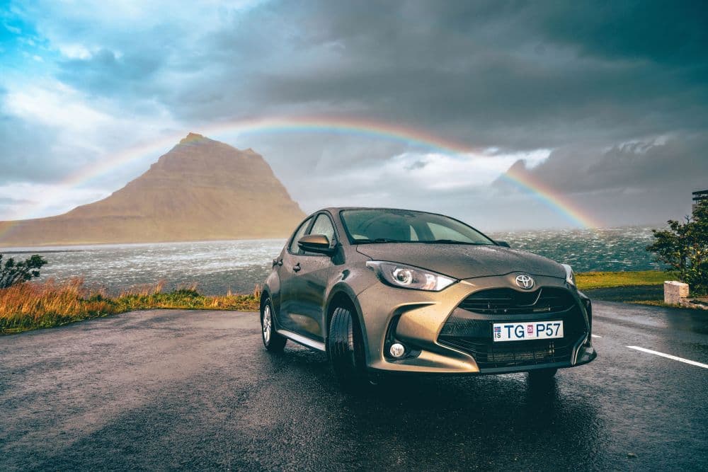 Petite Toyota Yaris garée devant la montagne Kirkjufell, péninsule de Snæfellsnes.
