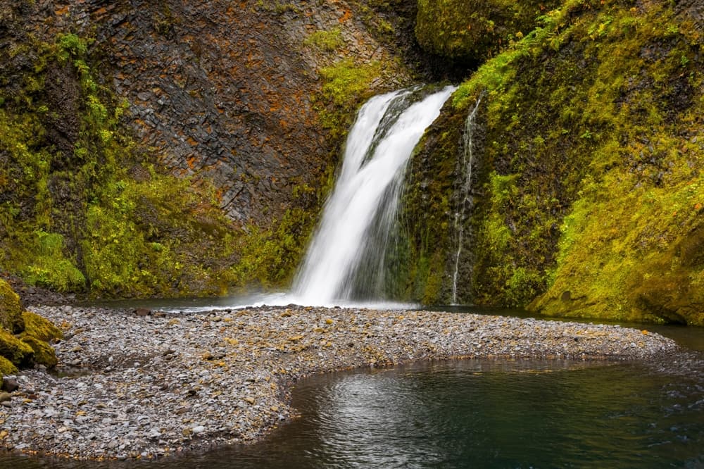 Þakgil Canyon (near Vík) Secluded waterfall tumbling into a quiet rocky pool surrounded by mossy cliffs in rural Iceland.