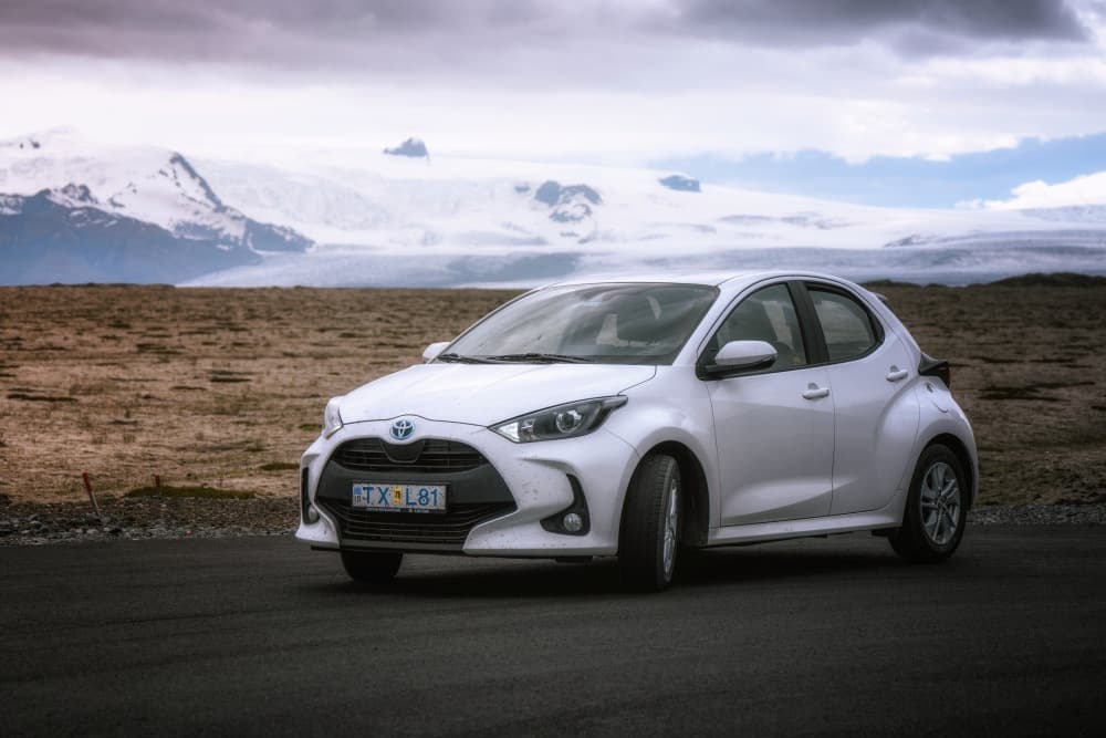Coche económico aparcado frente a un glaciar en Islandia.