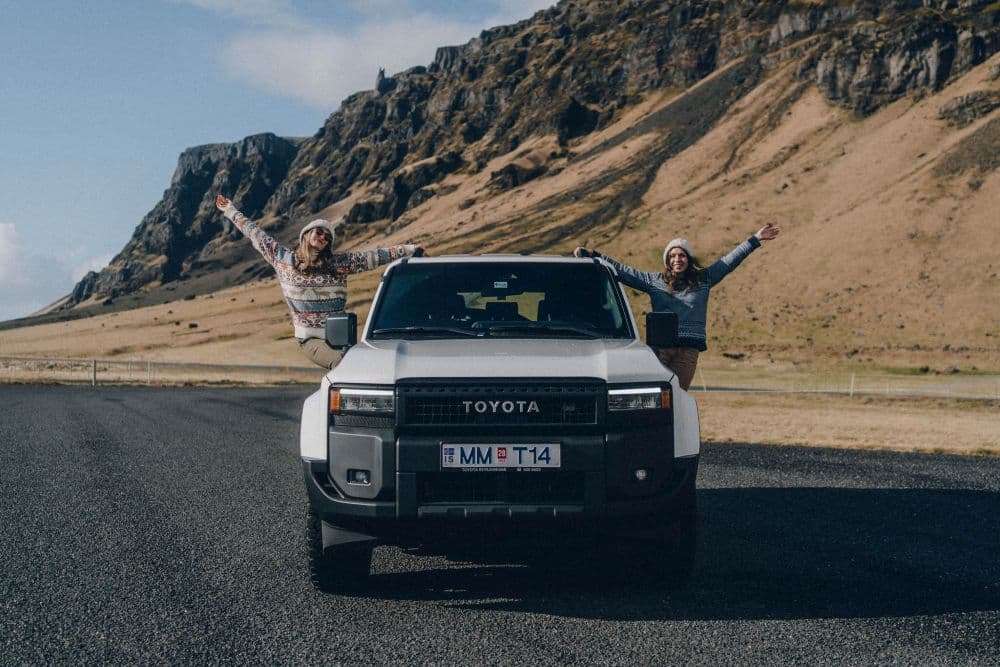 Dos mujeres con un gran coche 4x4 de alquiler en Islandia.