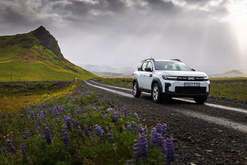 Rental car on gravel road in Iceland White Dacia Duster rental car in Iceland on a gravel road.