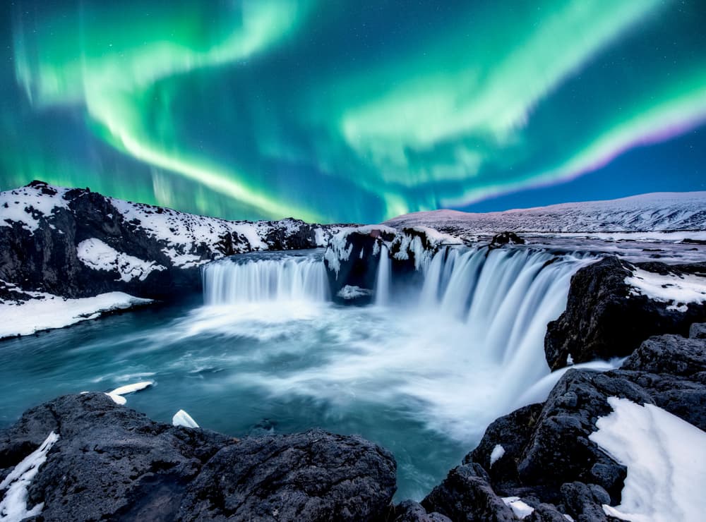 Nordlichter über dem Wasserfall Goðafoss im Norden Islands.