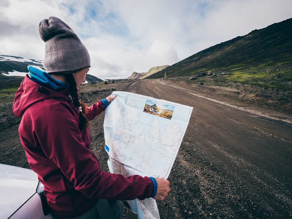 Papierkarte in Island. Frauen betrachten eine Papierkarte in Island.