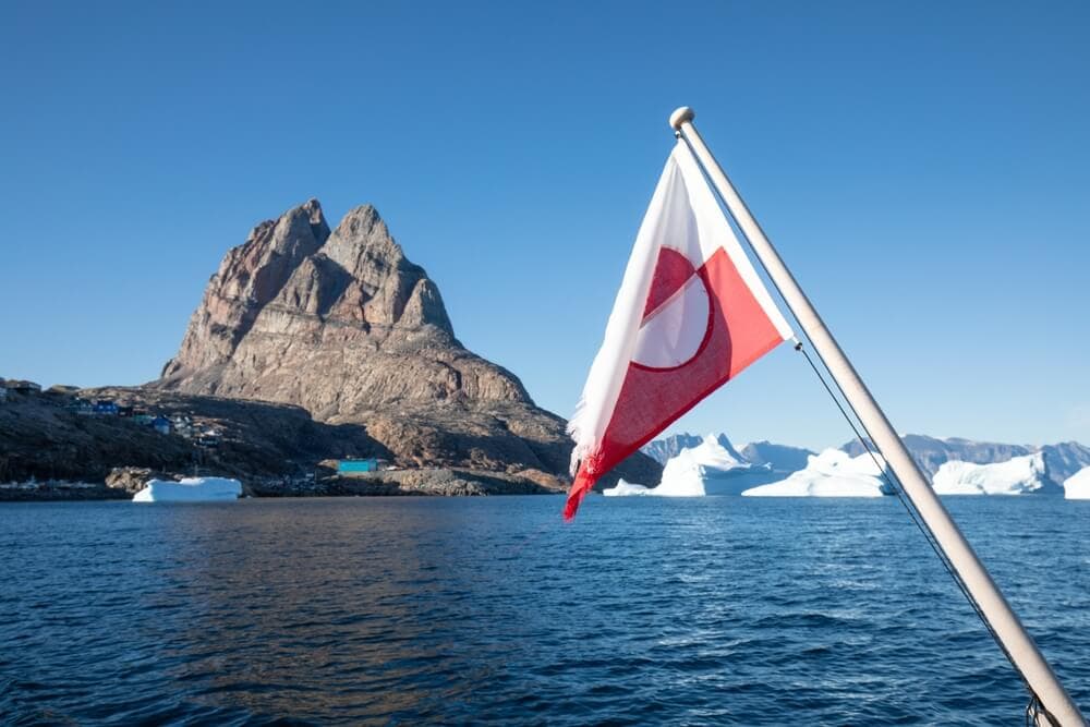 Greenland flag. Greenland flag and icebergs seeing from a boat in Greenland.