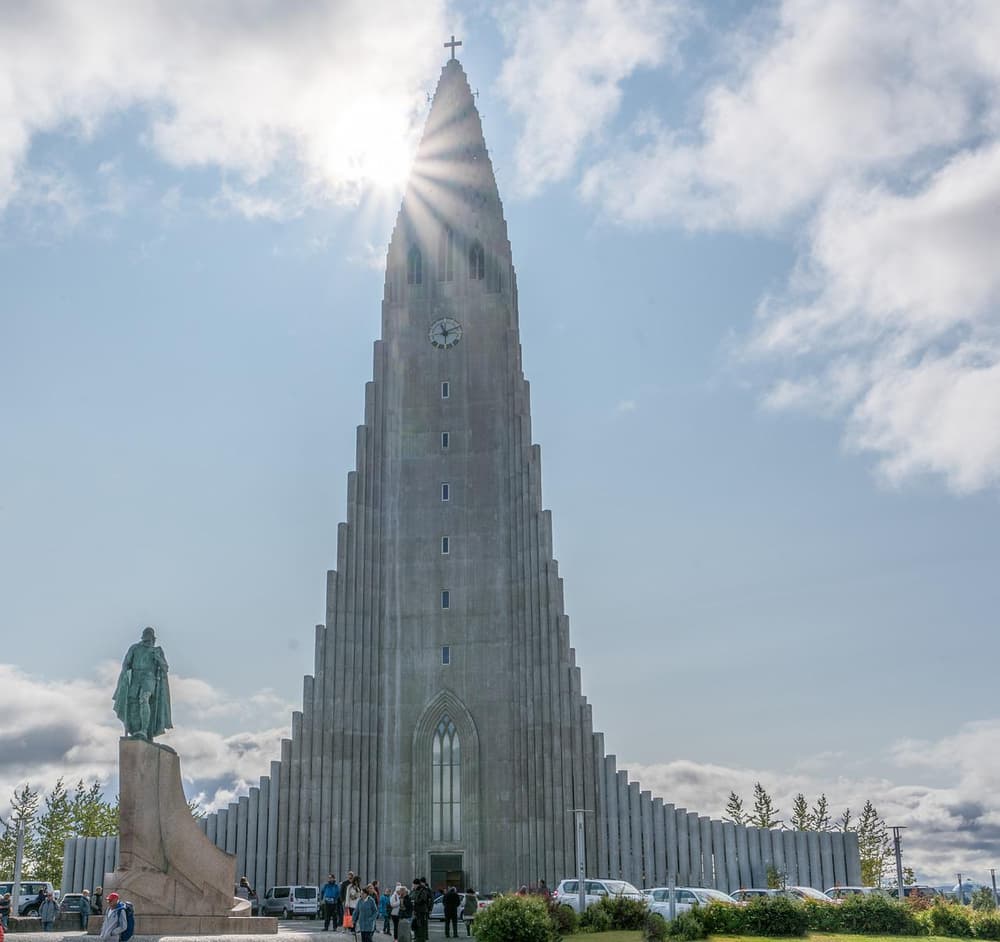 Hallgrímskirkja church tower. Hallgrímskirkja church tower rising above a statue and parked cars
