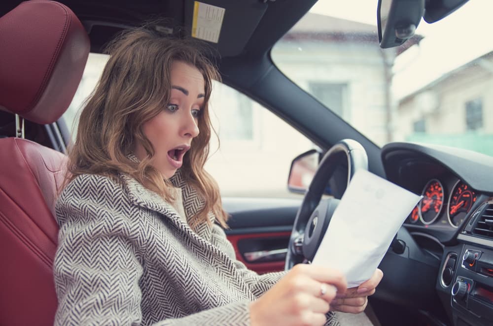 Zero deposit vs payments Women looking at papers inside of a rental car.