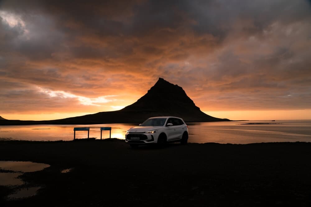 EV rental car at Kirkjufell mountain at Snæfellsnes peninusla summer evening.