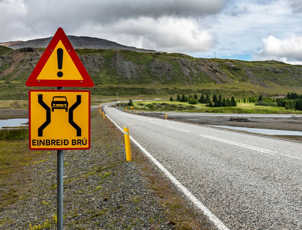 Panneau de signalisation pour un pont à voie unique sur une route rurale islandaise.