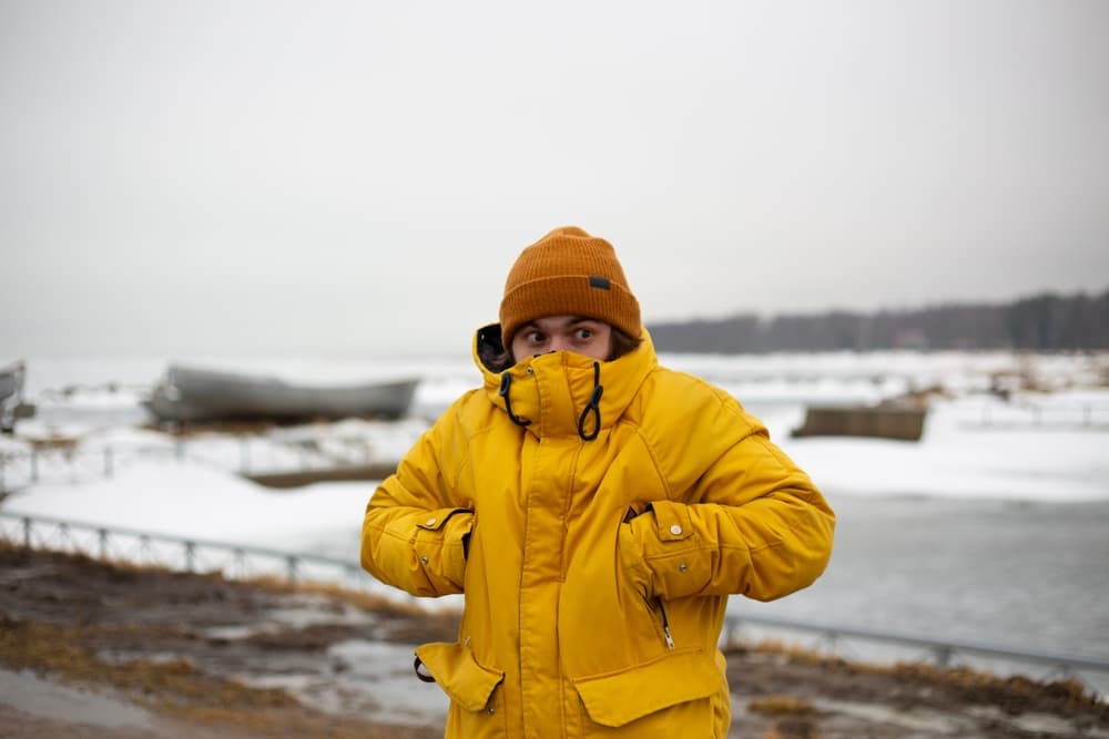 Cold in iceland. Men in yellow snow jacket in cold weather in Iceland.