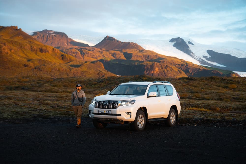 4x4 rental car in the mountains of Iceland Man walking to his Toyota Land Cruiser 4x4 rental car in the mountains of Iceland.