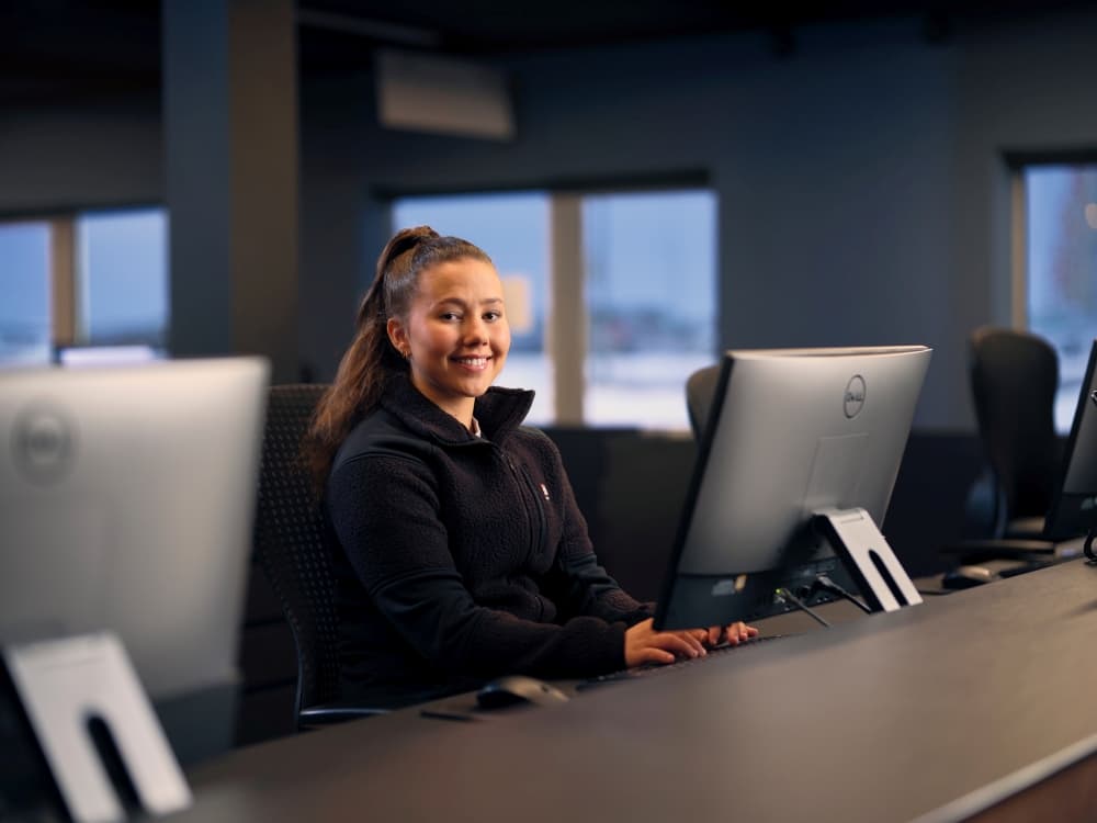 Blue Car Rental staff member sitting behind the desk at the Keflavik airport office.