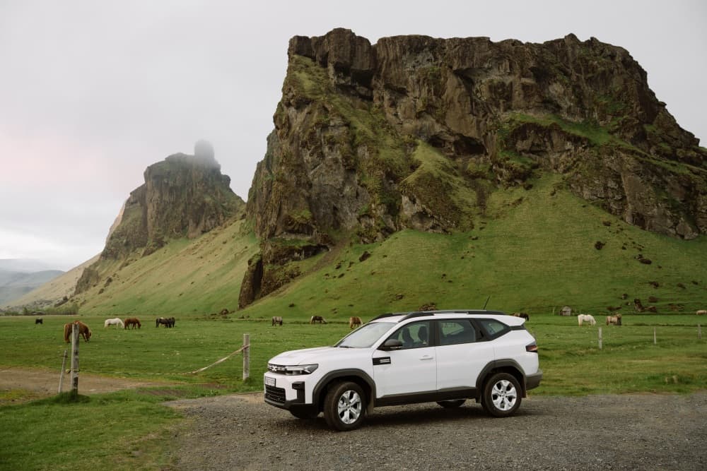 White 4x4 in Iceland mountains. White 4x4 Dacia Duster in green summer Iceland mountains.