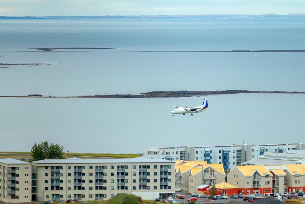 Small airplane flying over Reykjavik to lend at Reykjavik airport. 