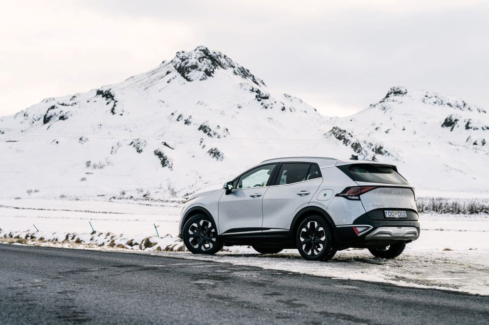 SUV Kia Sportage blanc roulant prudemment sur une route glacée en Islande.