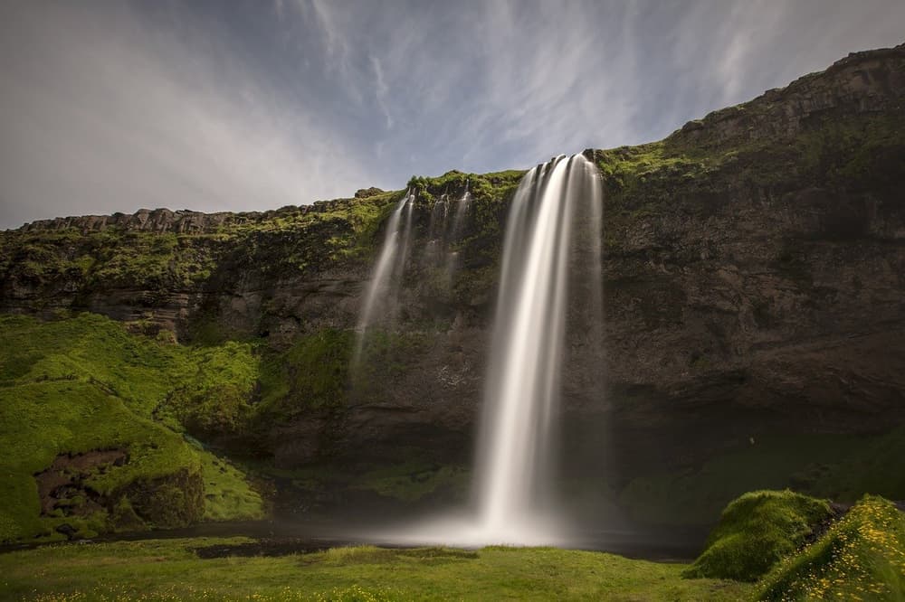 Seljalandsfoss in full flow. Seljalandsfoss waterfall cascading over a mossy cliff edge
