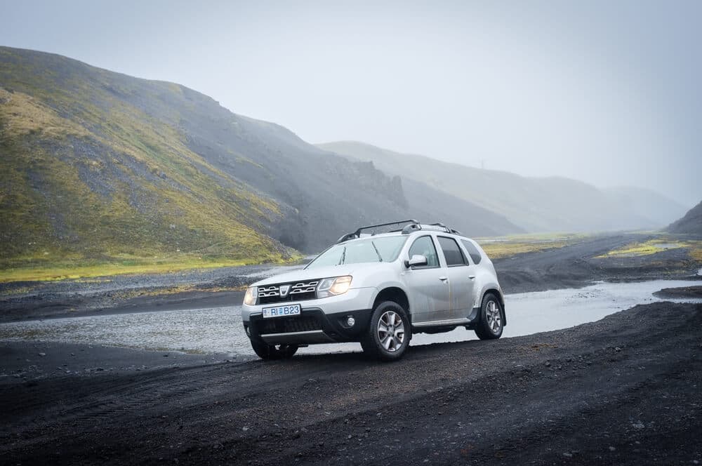 Blue Car Rental best 4x4 rental in iceland Dacia Duster crossing a river in Iceland's highland.