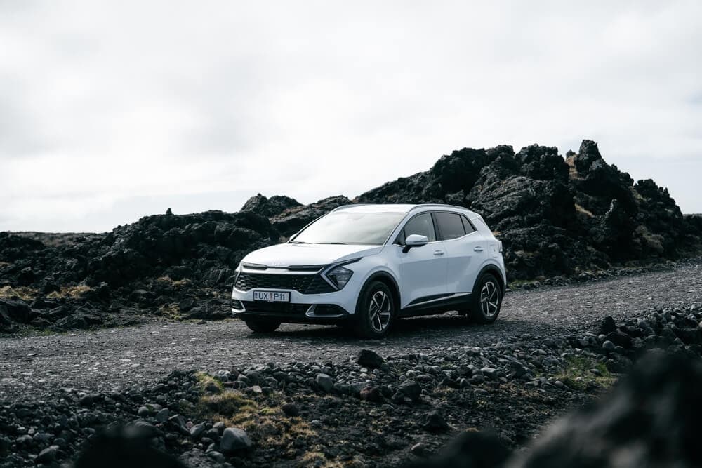 Kia Sportage from Blue Car Rental driving in a cold lava field.