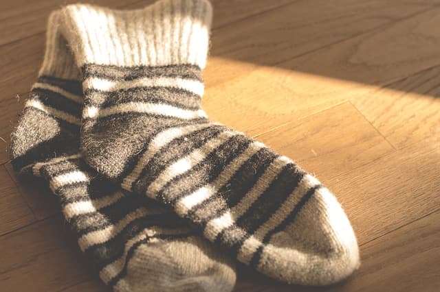 Warm wool socks for winter. Striped wool socks lying on a wooden floor