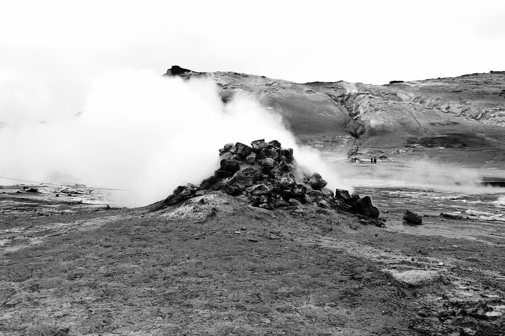 Sulfur steam vents in Iceland. Steam rising from a dark sulfur mound on barren volcanic ground in Iceland