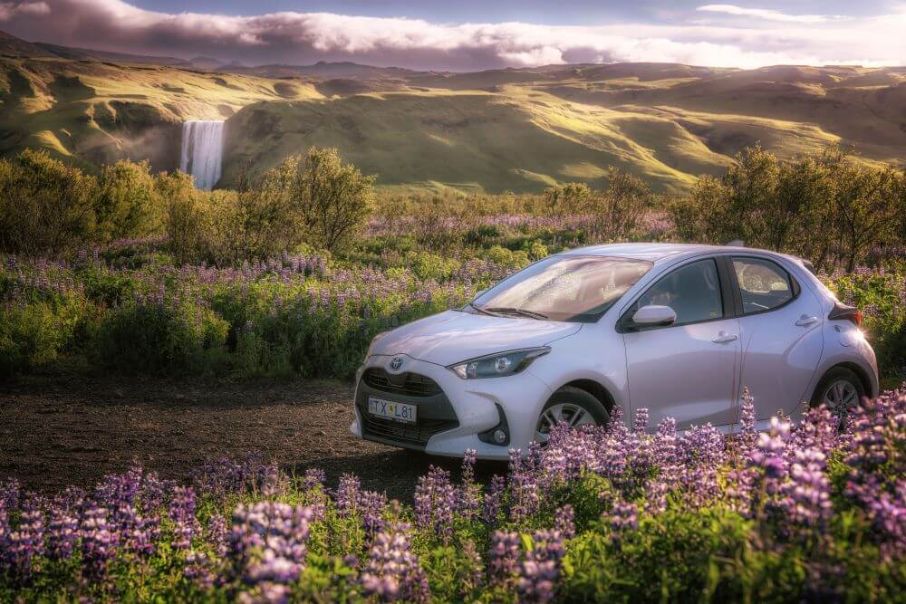 Road condition in May. Toyota Yaris at Skogafoss waterfall in Iceland