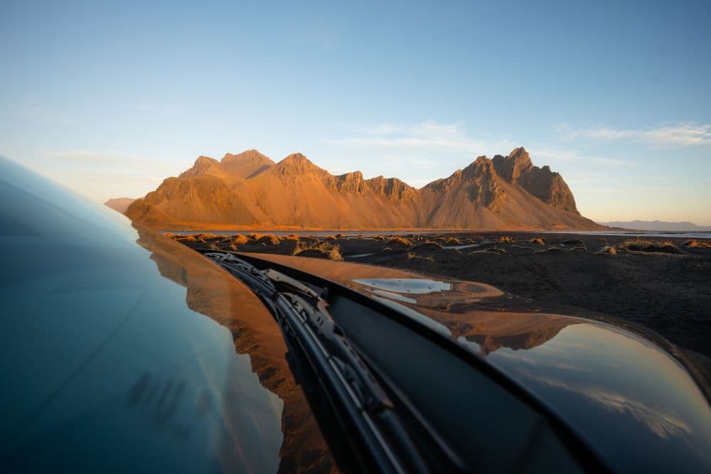 Iceland mountain driving. Car driving on the road in iceland with mountains in the background.