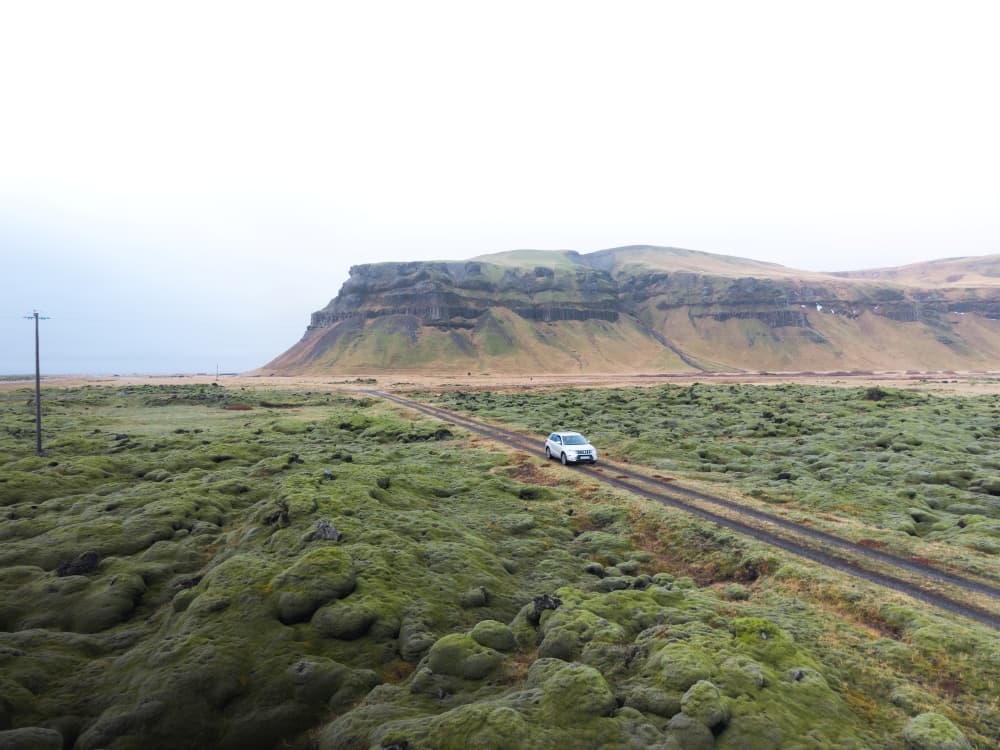 Silver Suzuki Vitara on a gravel road in Iceland in summer.
