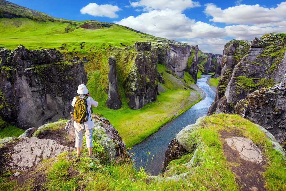 Fjadurargljufur Person standing in front of Fjadurargljufur in summer.