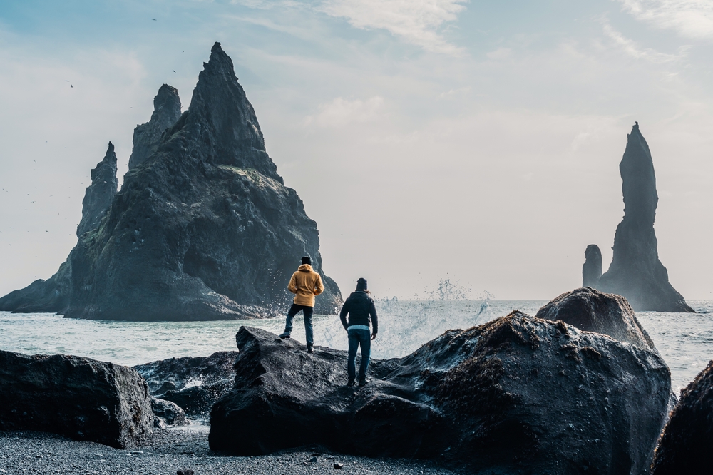 Reynisfjara beach People standing on the rocks at Reynisfjara beach