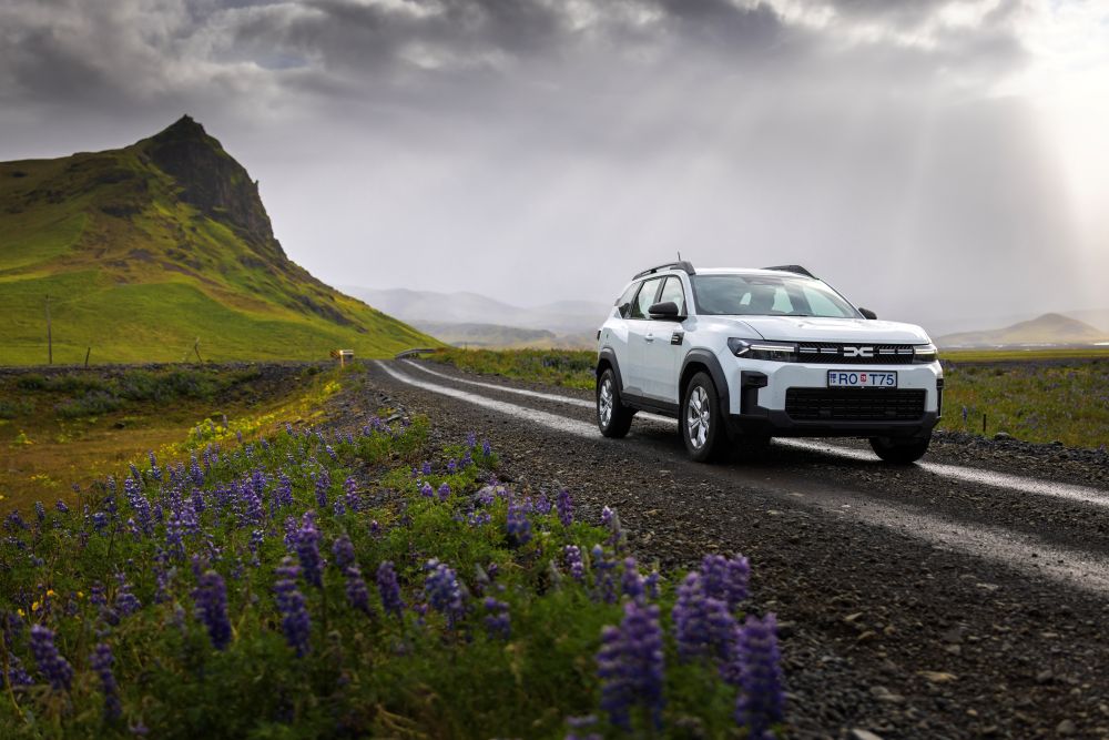 Rental car on gravel road in Iceland White Dacia Duster rental car in Iceland on a gravel road.