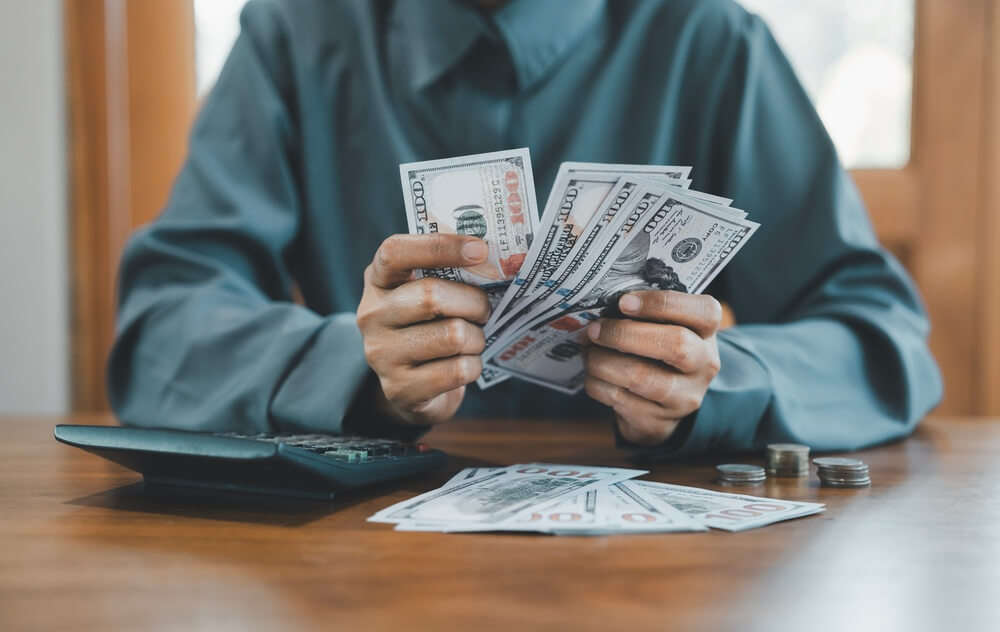 Counting dollar notes and calculator.