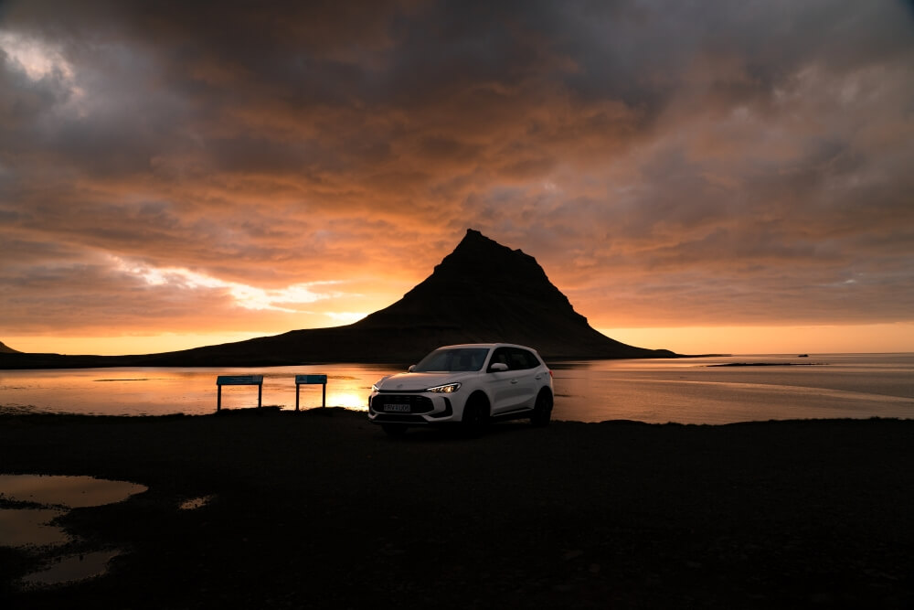 EV rental car at Kirkjufell mountain at Snæfellsnes peninusla summer evening.