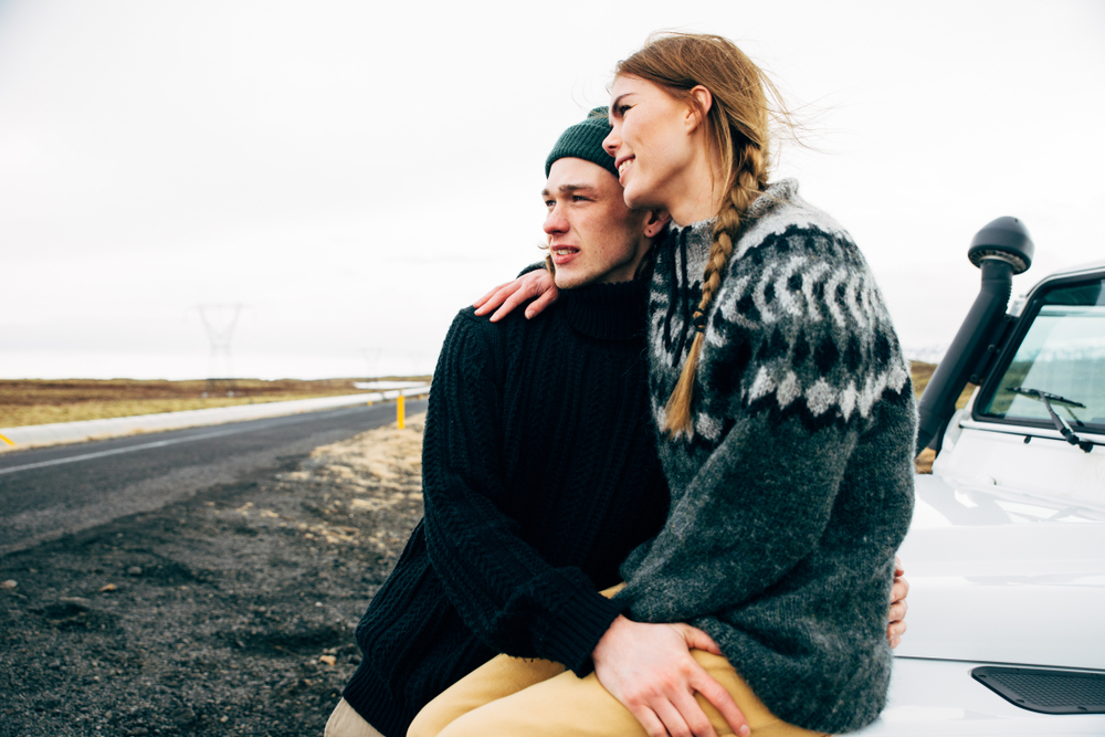 Icelandic couple. Couple sitting on a car in Iceland wearing wool sweaters.