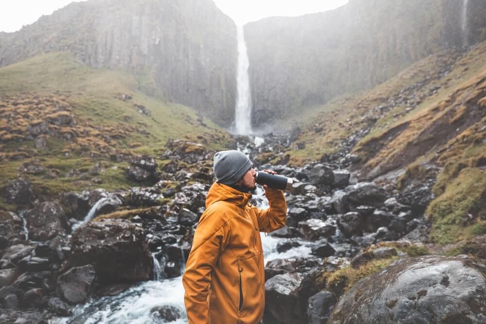 Man drinking from a stream in Iceland.