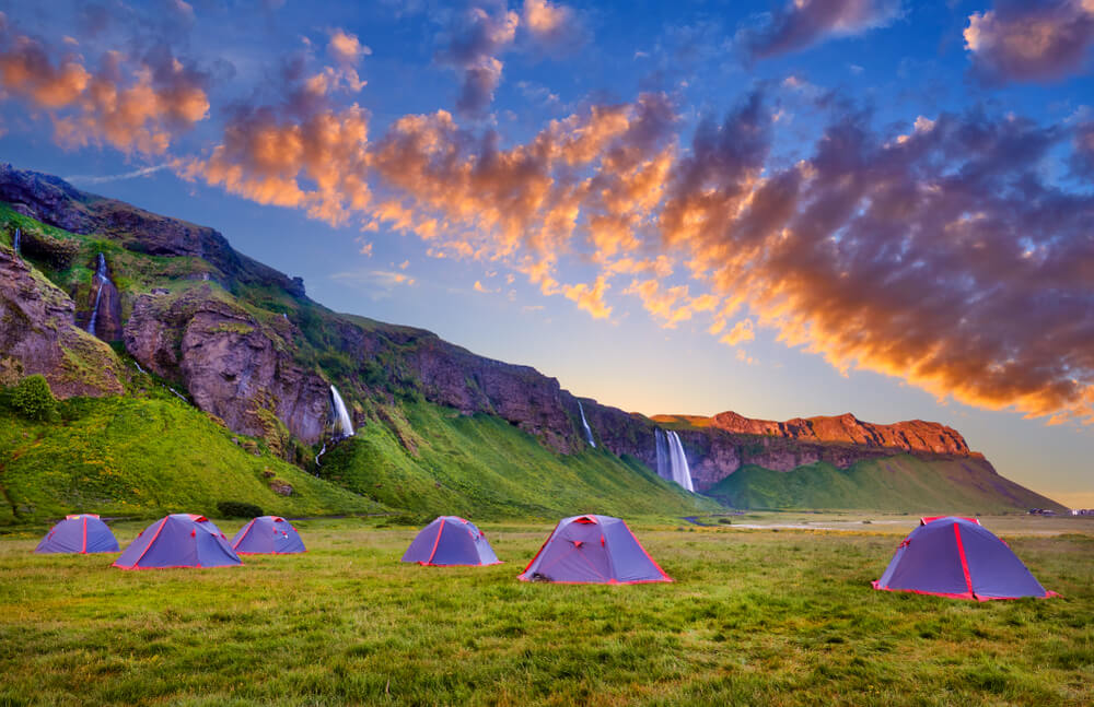 Tents at Seljalandsfoss waterfall in summer.