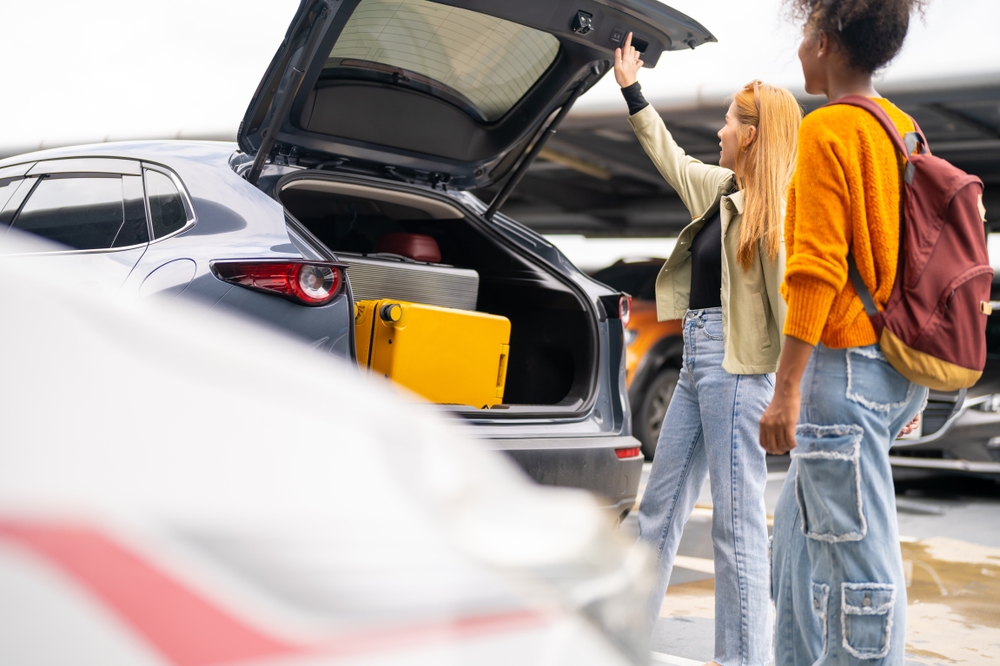 People loading their rental car with luggage at Keflavik airport.