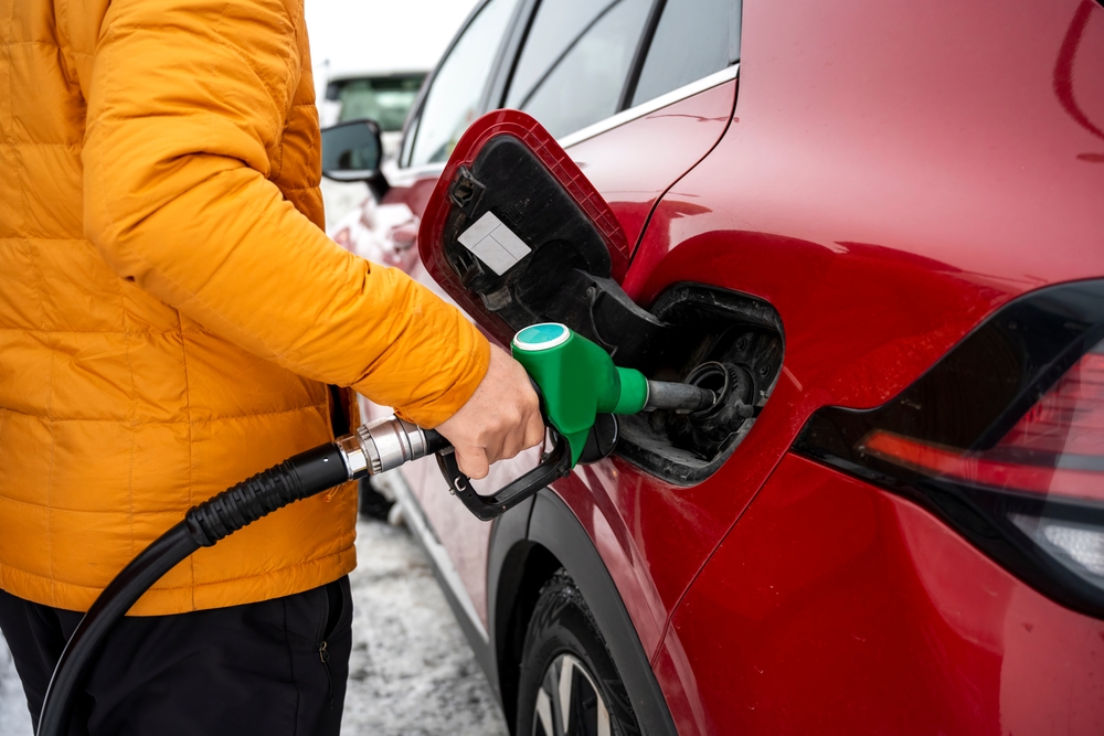 Refuelling in Iceland. Person putting fuel on a red rental car in Iceland.