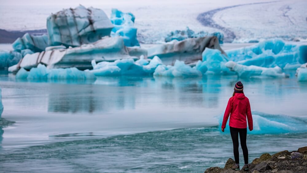 women standing in front of jokulsarlon glacier lagoon in Iceland.