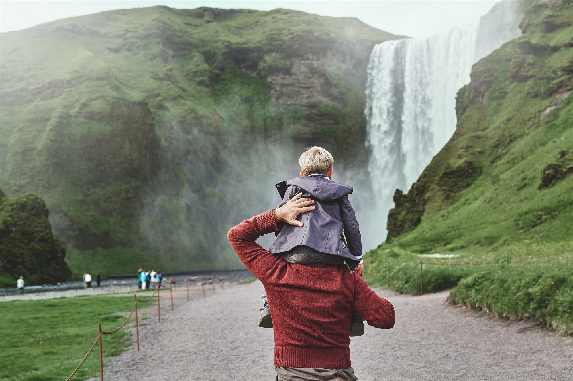 Father and son at Skogarfoss waterfall.